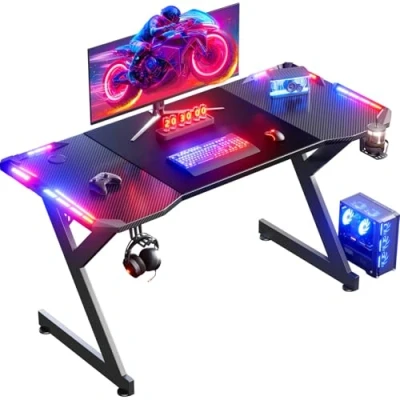 Imagen de HLFURNIEU 140 x 60 cm LED Mesa Gaming, Gamer de Superficie Fibra Carbono, Escritorio Gaming Ergonómica con Portavasos y Gancho para Auriculares, Negro